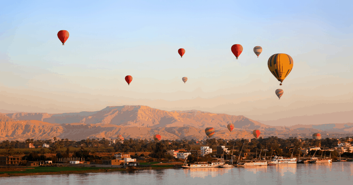 Hot air balloons floating over the Nile River in Luxor at sunrise. Image credit: iStock