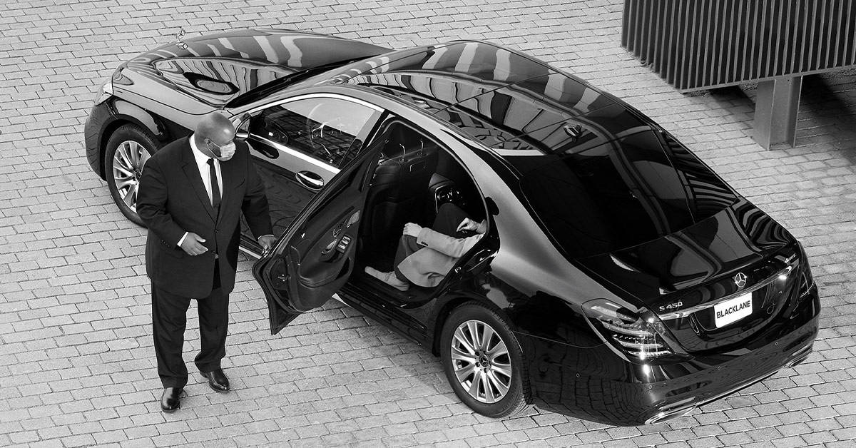 Blacklane chauffeur opens the door for a guest.