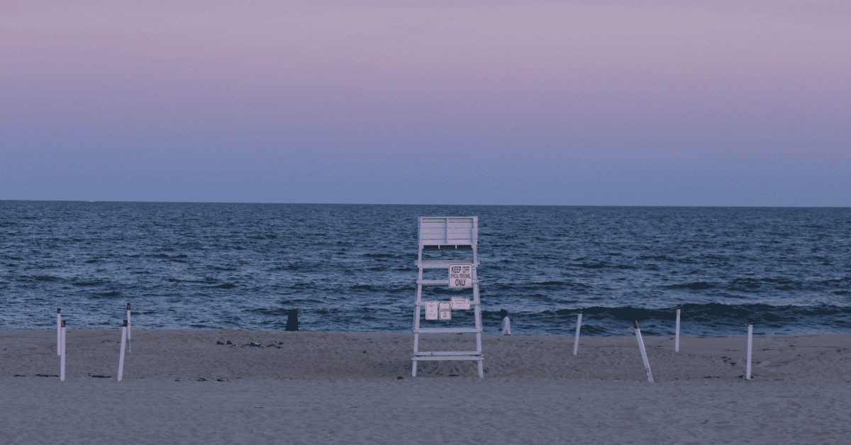 a lifeguard chair sitting on the beach next to the ocean.
