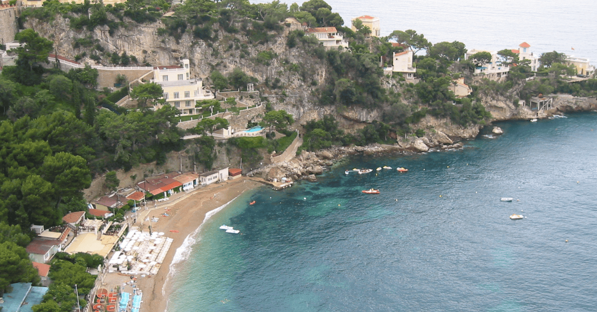 an aerial view of a beach with boats on the water.