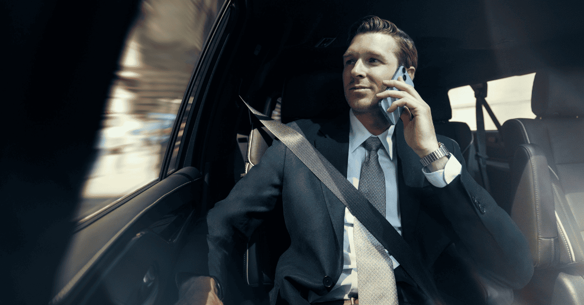 a man sitting in a car talking on a cell phone.