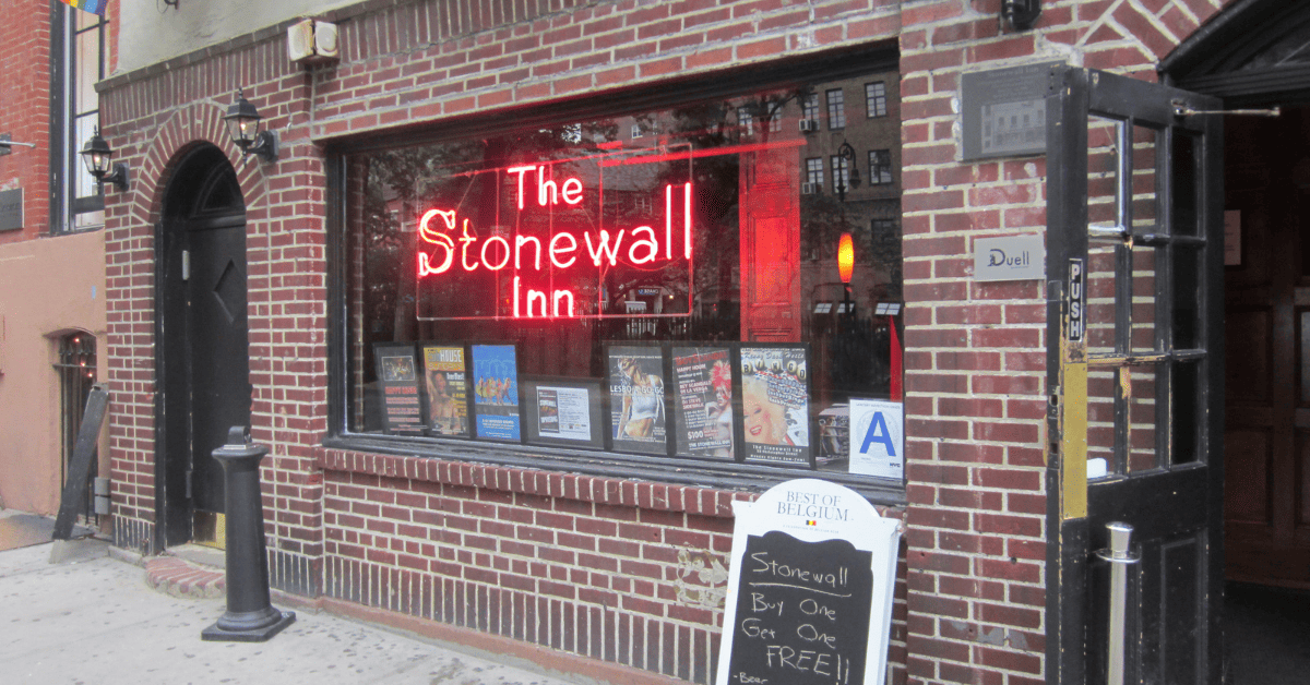 a brick building with a neon sign in the window.