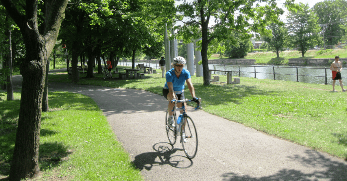 A person riding a bike on a path next to a body of water.