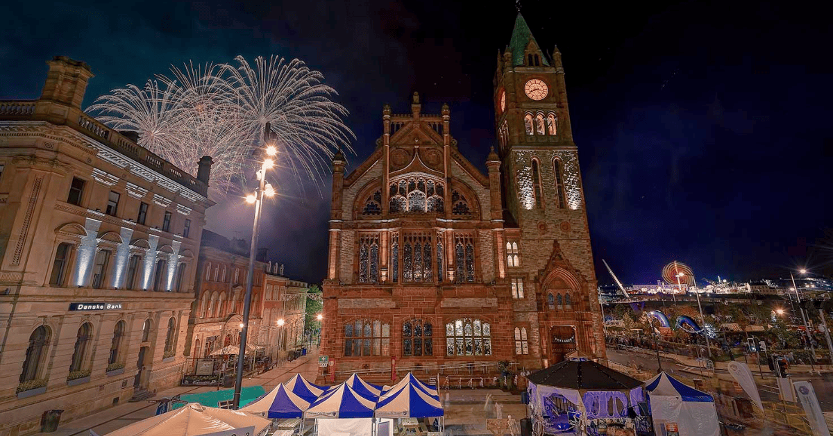 a building with a clock tower and fireworks in the background