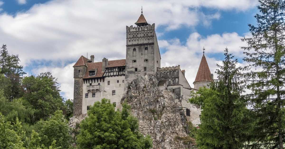 a castle on a rock with Bran Castle in the background