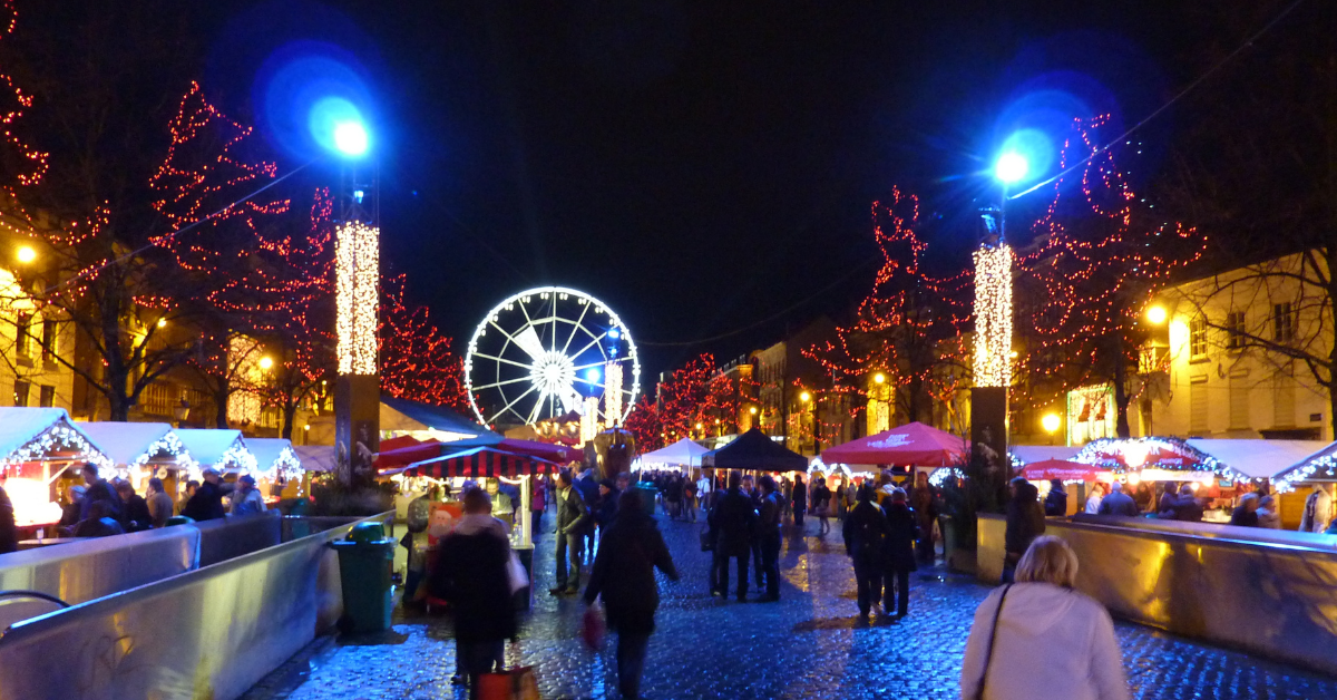 a crowd of people walking in a city at night with ornaments and lights everywhere