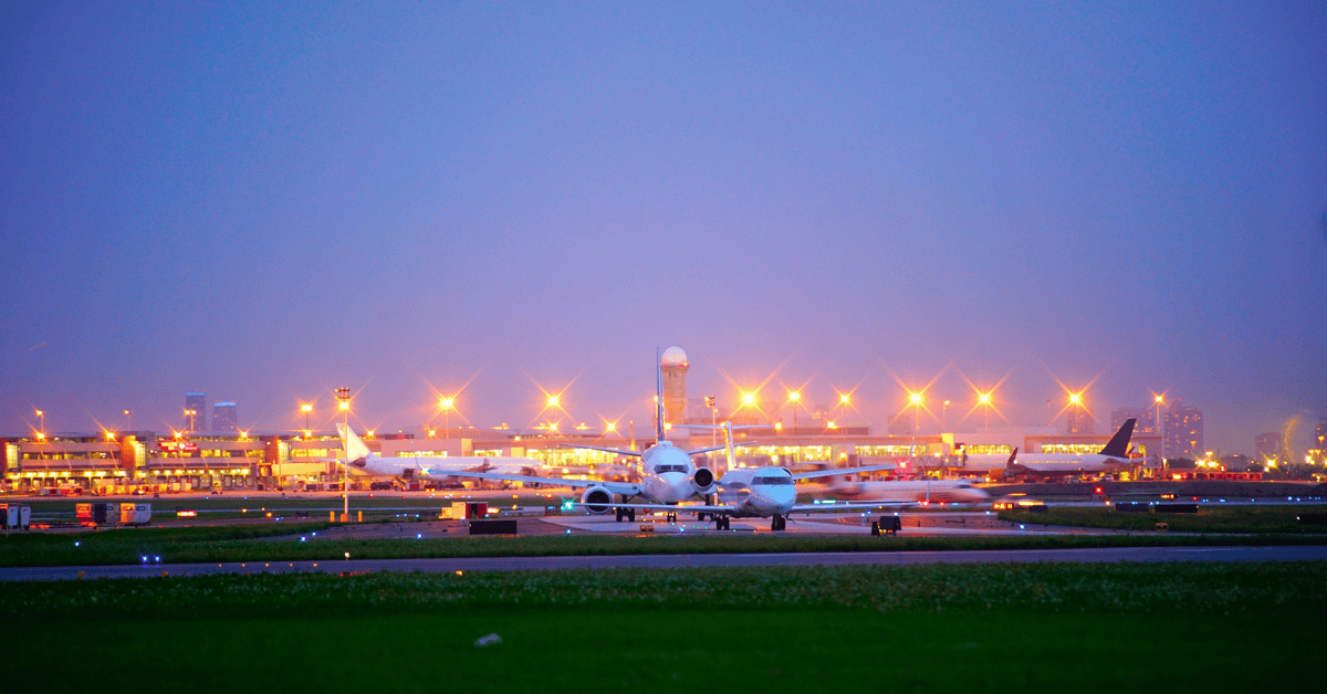 A busy airport with multiple planes parked on the runway, ready for takeoff or awaiting passengers.